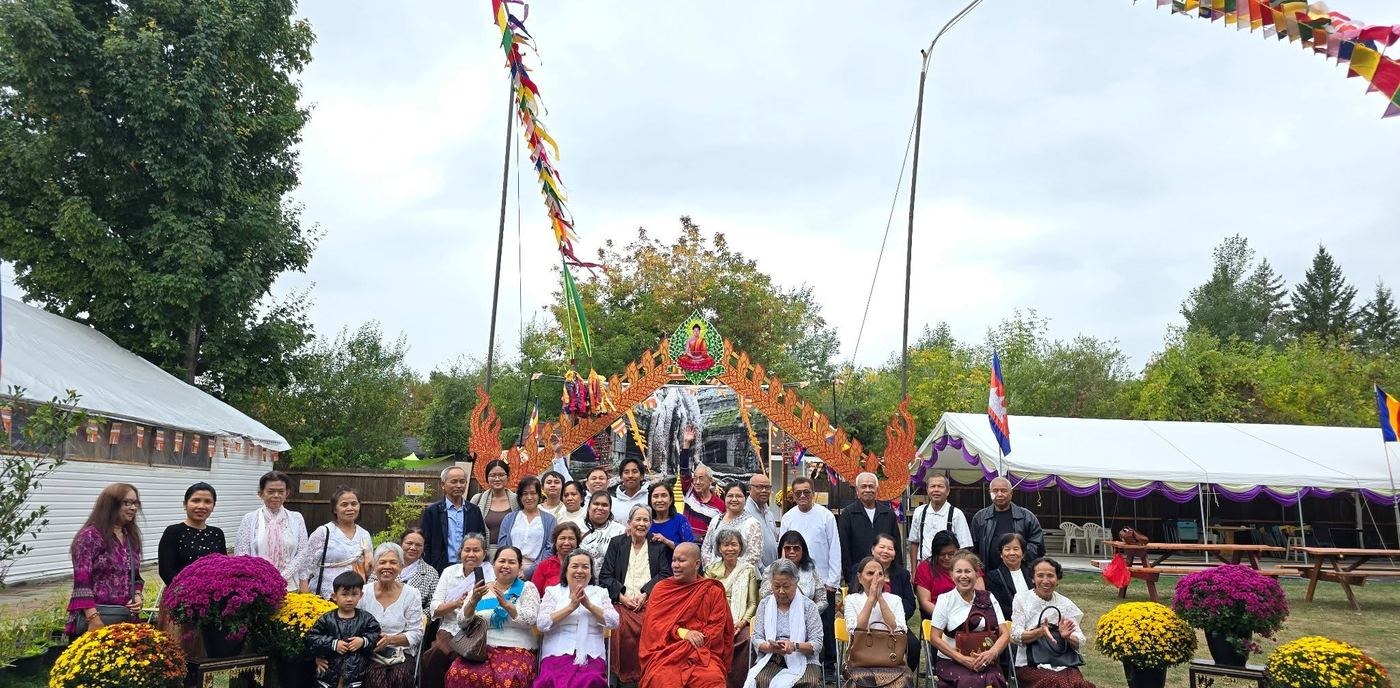 Guests seated in front of the decorated gateway, with festival tents behind them