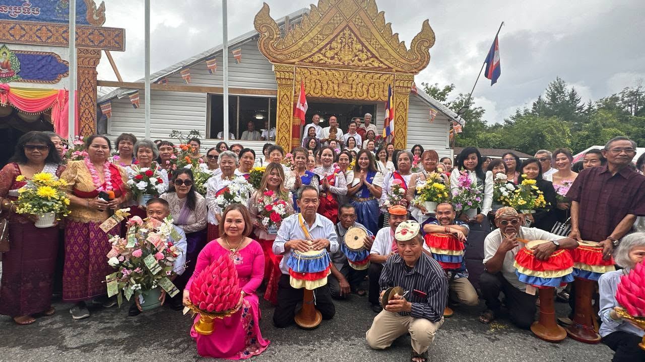 The community gathered in front of the golden temple gate, holding flowers and offerings